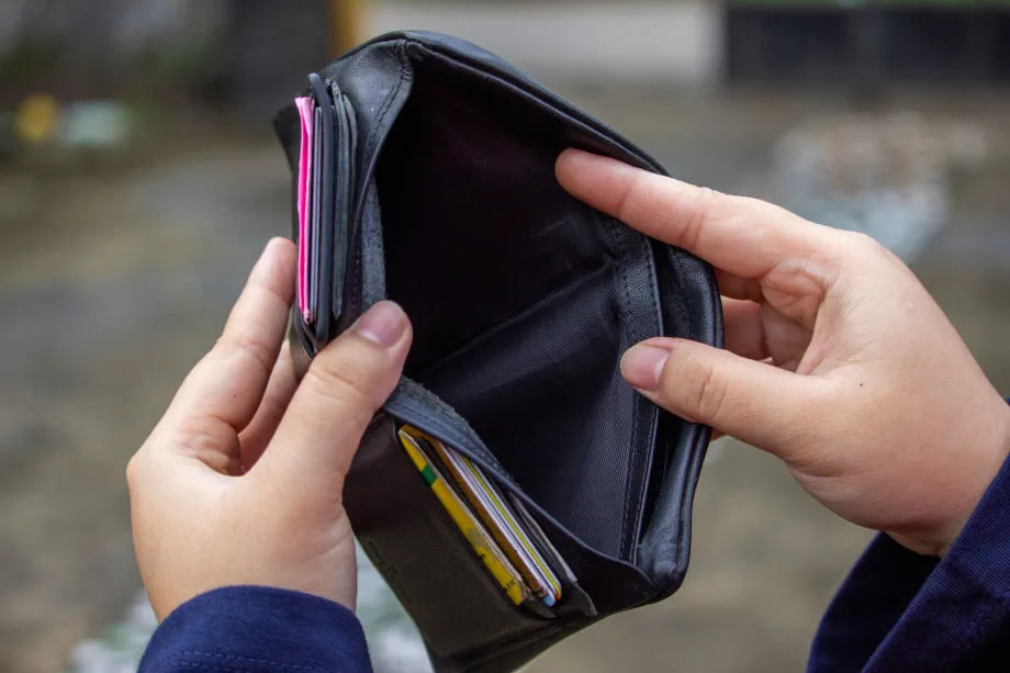 Woman's hands holding an wallet empty of cash