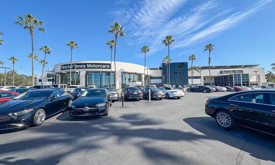 outside shot of Fletcher Jones Motorcars, white building with various cars out front