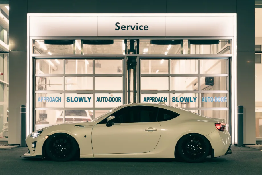 White backlit BRZ sitting in front of mechanic.