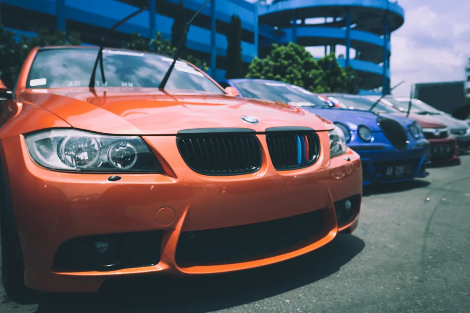 Orange BMW with windshield wipers sticking up.