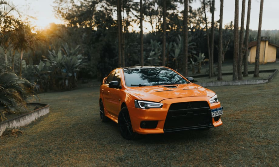Orange Mitsubishi car on grass