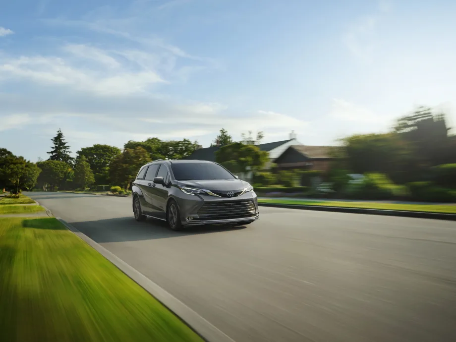 Toyota Sienna car driving down road.