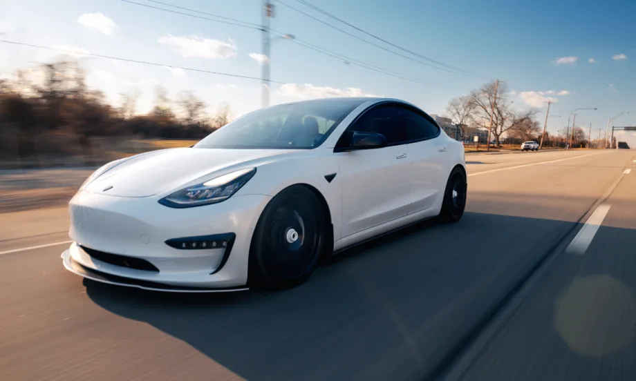 White Tesla car driving on road.