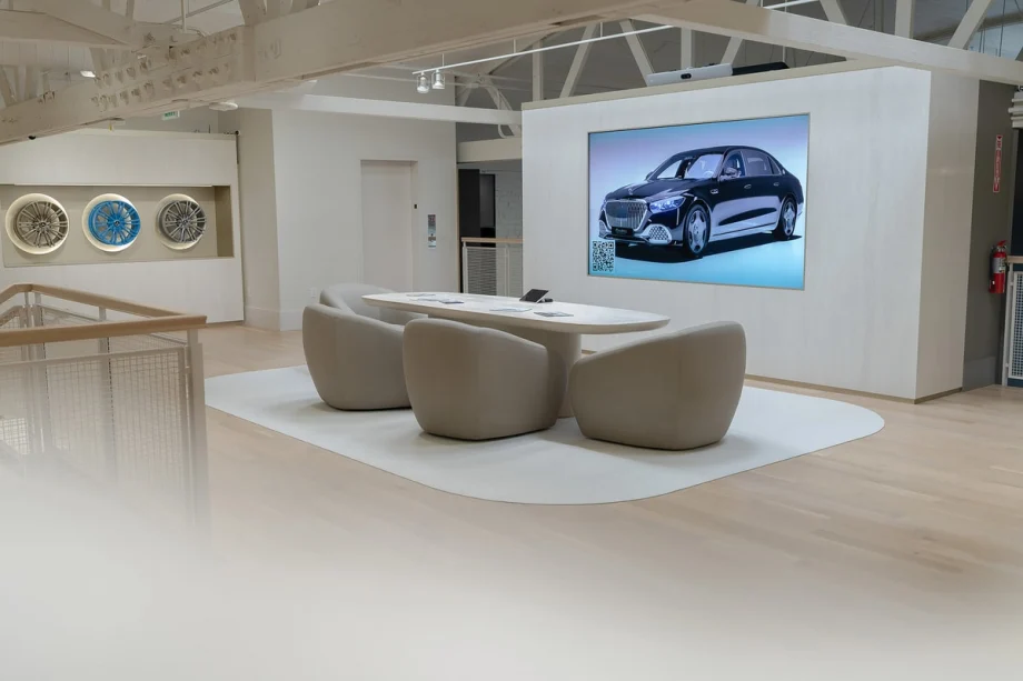 White meeting room in car dealership with rims displayed on wall and projected screen