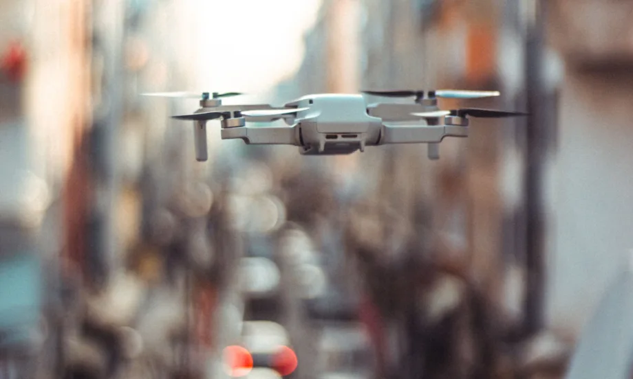 Drone flying in front of blurry background.