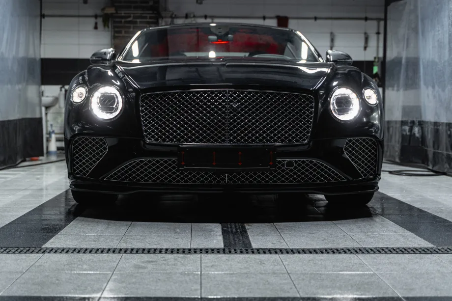 Front of black car with headlights on.