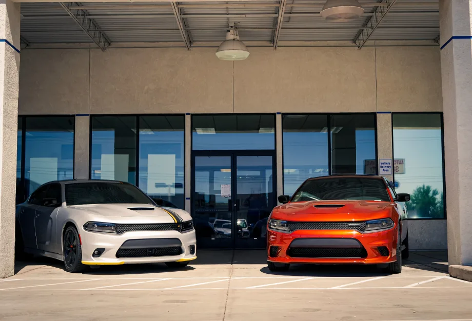 Two dodge cars outside of dealership.