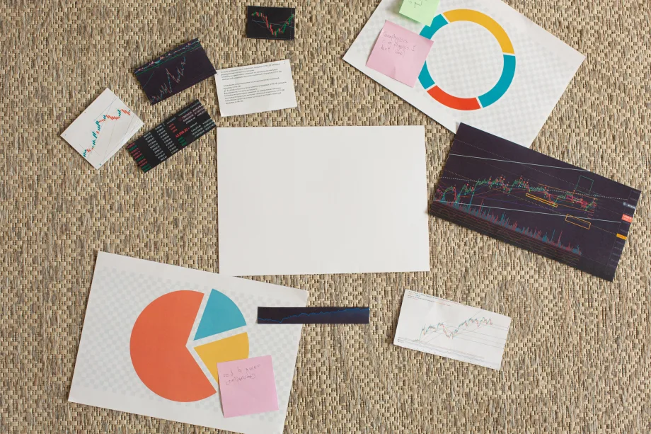 Various graphs and sheets of infographics laid out with handwritten post it notes.