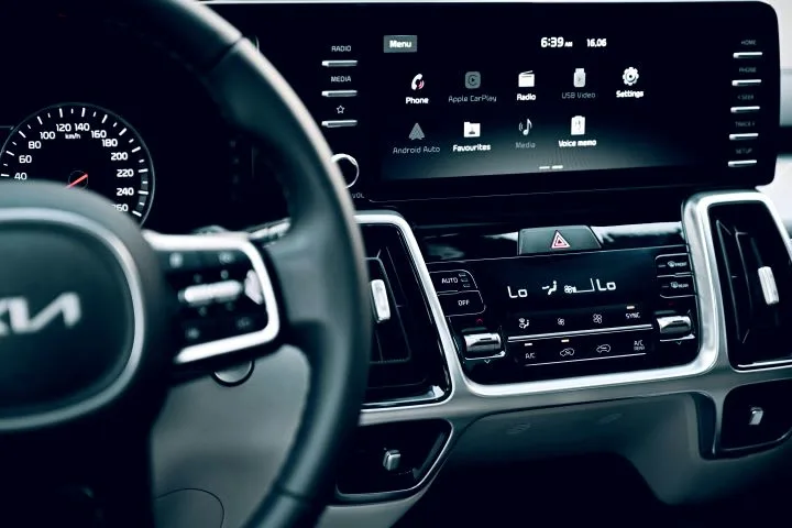 Phot of a dark Kia vehicle interior with steering part of steering wheel and dashboard