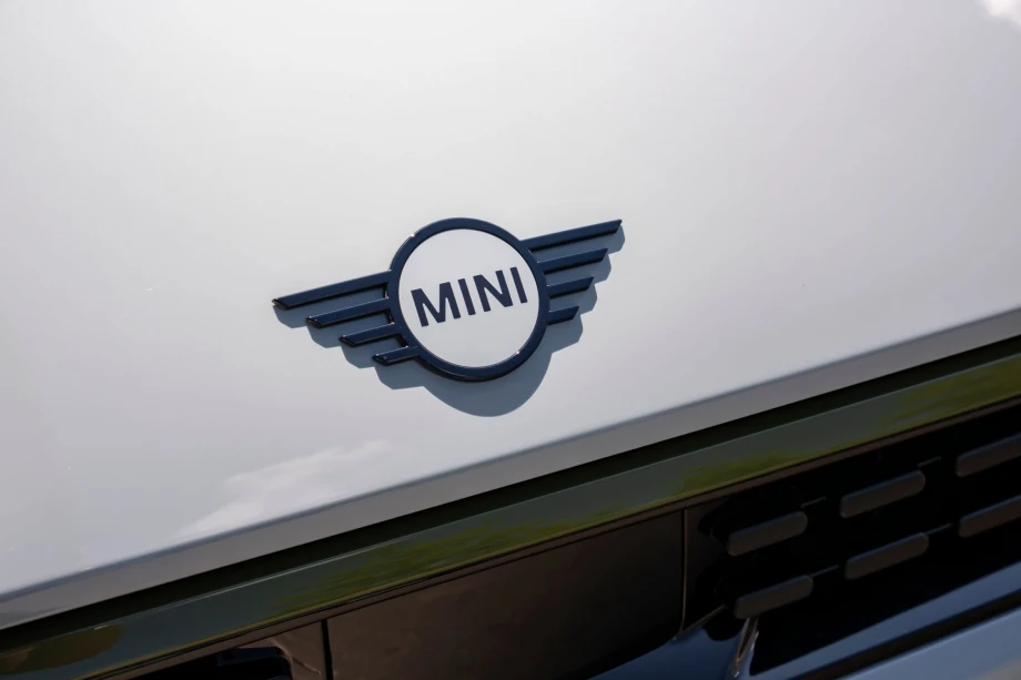 Photo of MINI nameplate on the hood of a white MINI Cooper