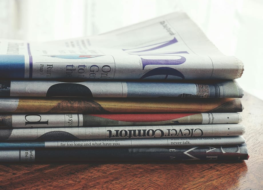 Photo of a stack of folded newspapers on a table