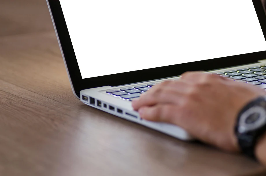 Photo of man's hand on laptop keyboard on a desk