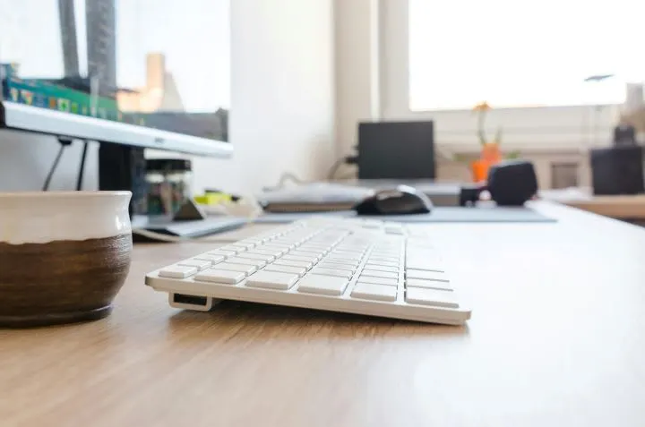 Photo of external keyboard on office deak next to window