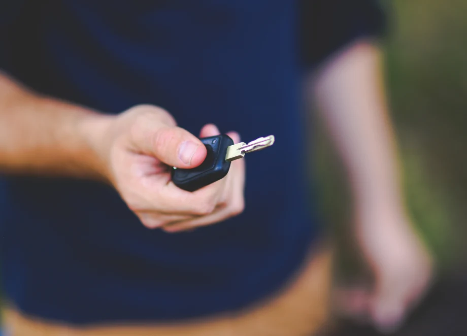 man holding out car key