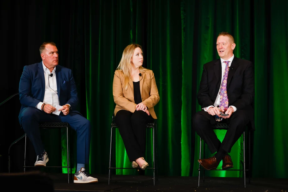 Two men and a woman on stage in discussion