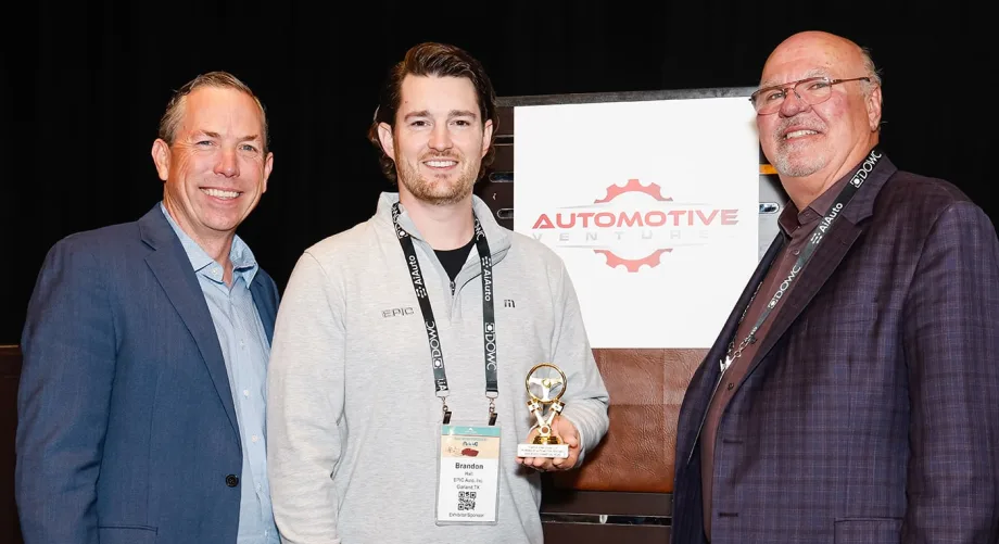 Photo of two men representing winning company, along with the award presenter