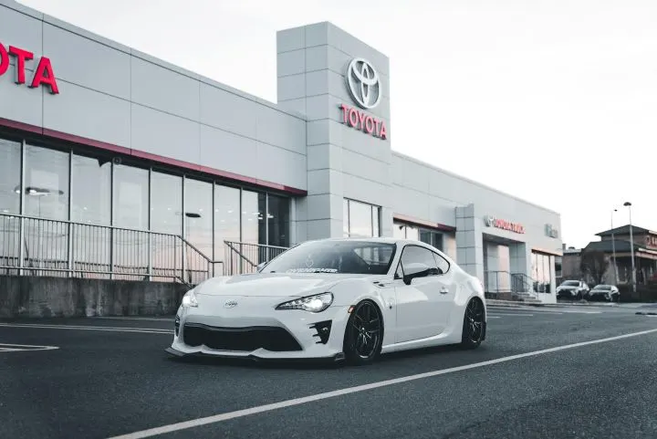 Photo of white Toyota car in front of dealership