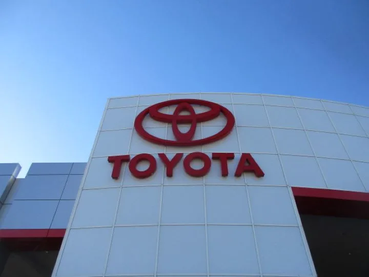 red Toyota logo on front of white dealership