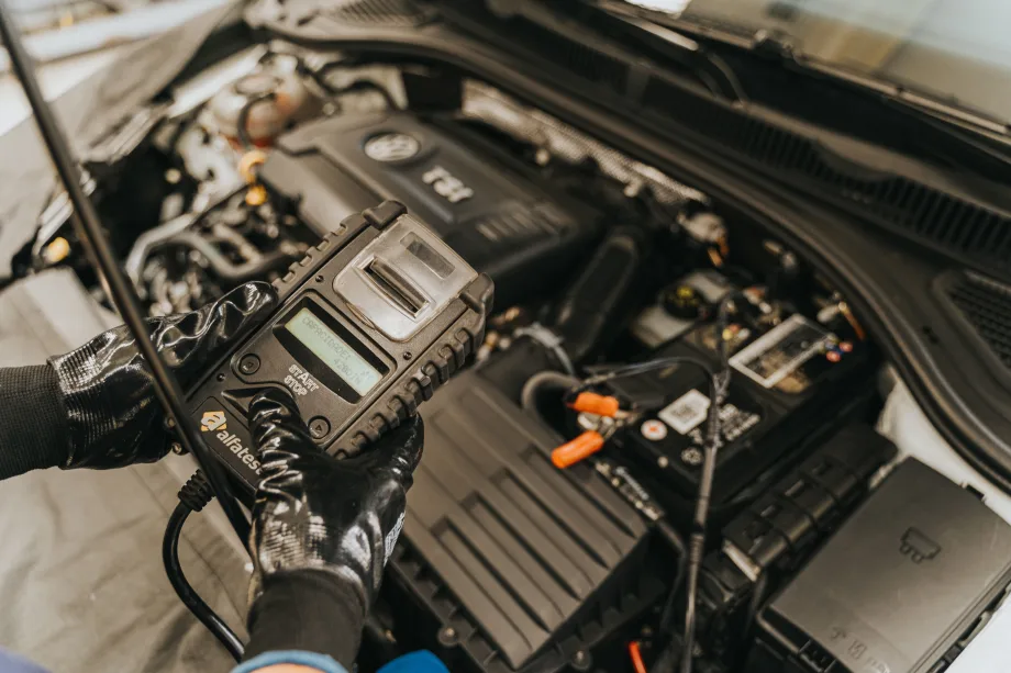 Mechanic holding digital device over an open vehicle engine