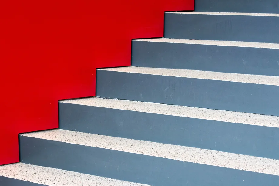 Staircase with no rails next to red-painted wall