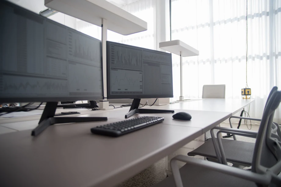 Two desktop computers side by side on otherwise empty office desk