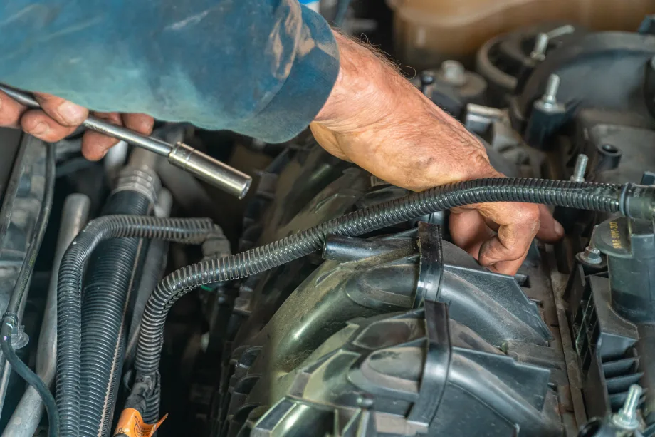 Mechanic's hand working in car engine