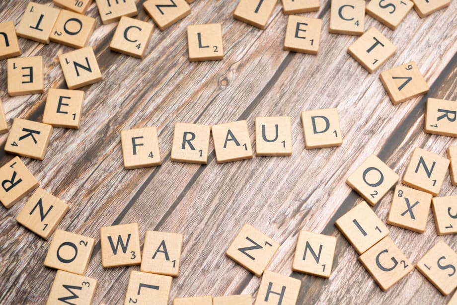 Scrabble letter tiles spelling fraud