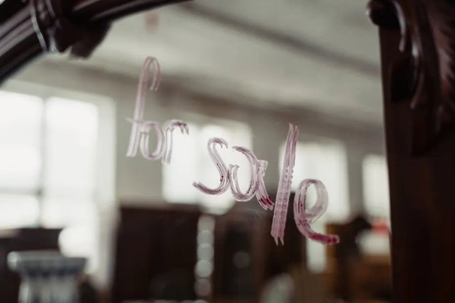 'for sale' written on a building window